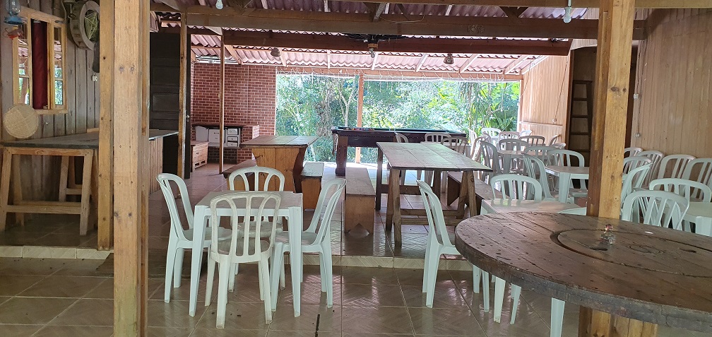 Interior do salão de eventos com mesas e cadeiras