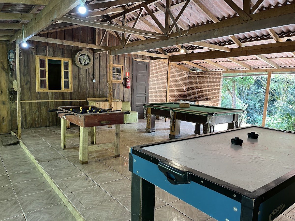 Salão coberto da Leo's Eventos e Chalés, com mesa de sinuca, pebolim e air hockey