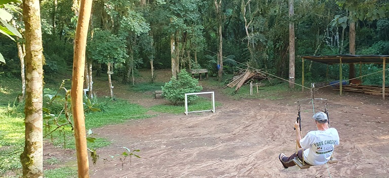 Pessoa descendo de tirolesa na área de lazer da propriedade